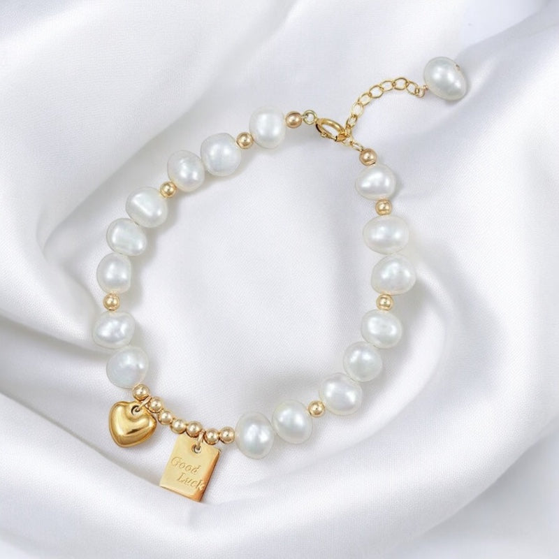 Pulsera de Perlas Blancas con Charms de Corazón y "Good Luck" – Elegancia y Significado